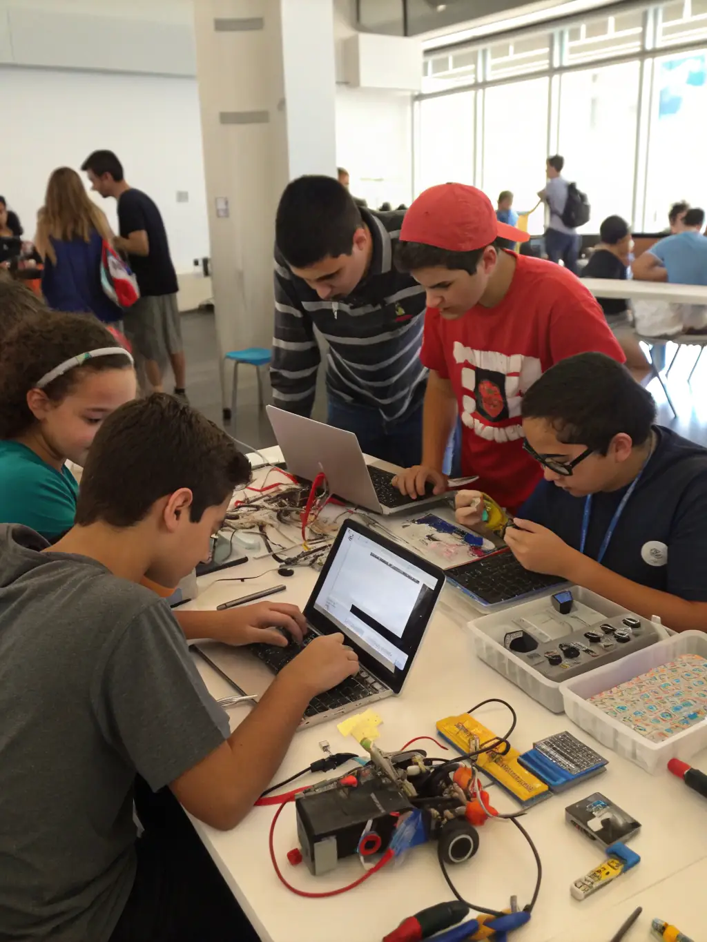 A group of young people working together on a go-kart engine in a brightly lit workshop, showcasing teamwork and hands-on learning.