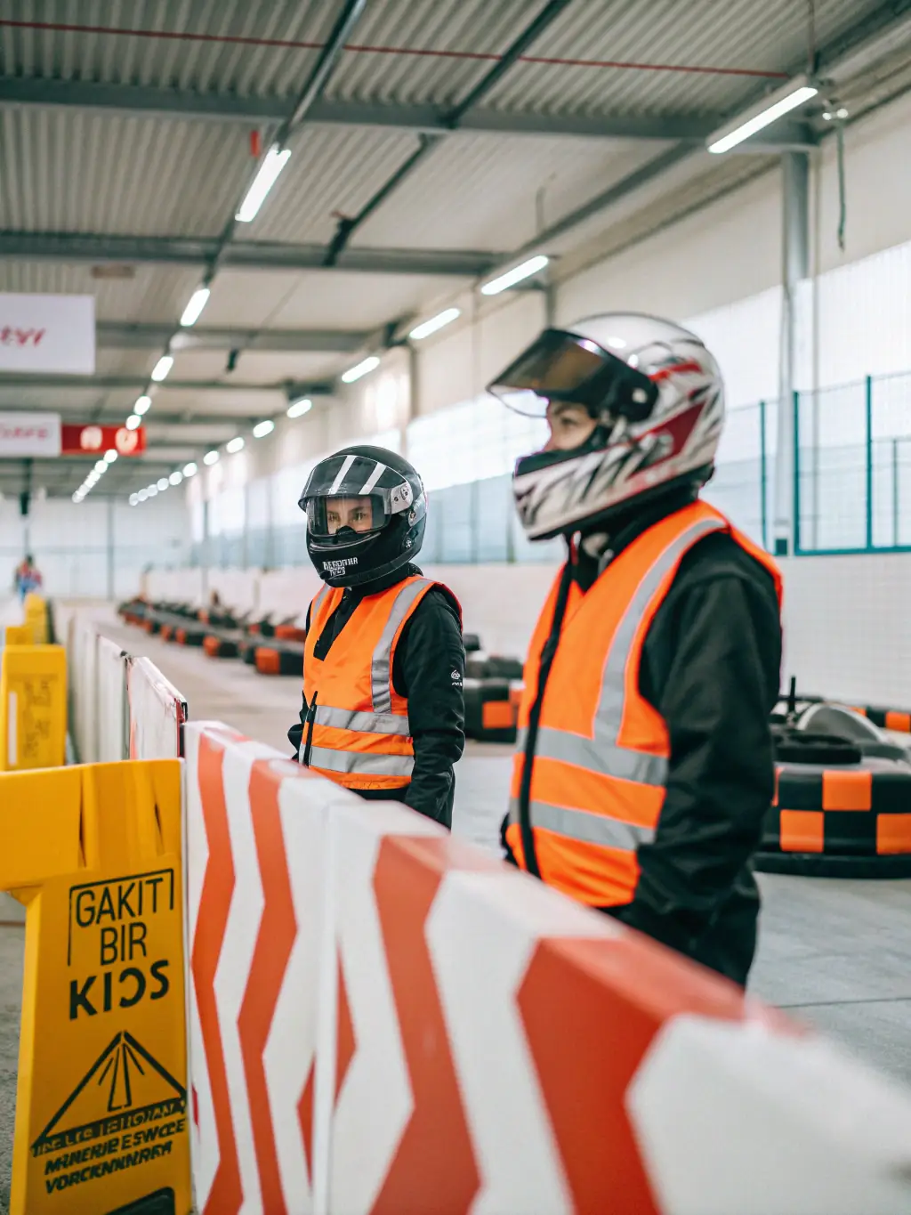 A volunteer instructor demonstrating safety procedures to a group of young participants at a motorsports event, emphasizing safety and responsibility.